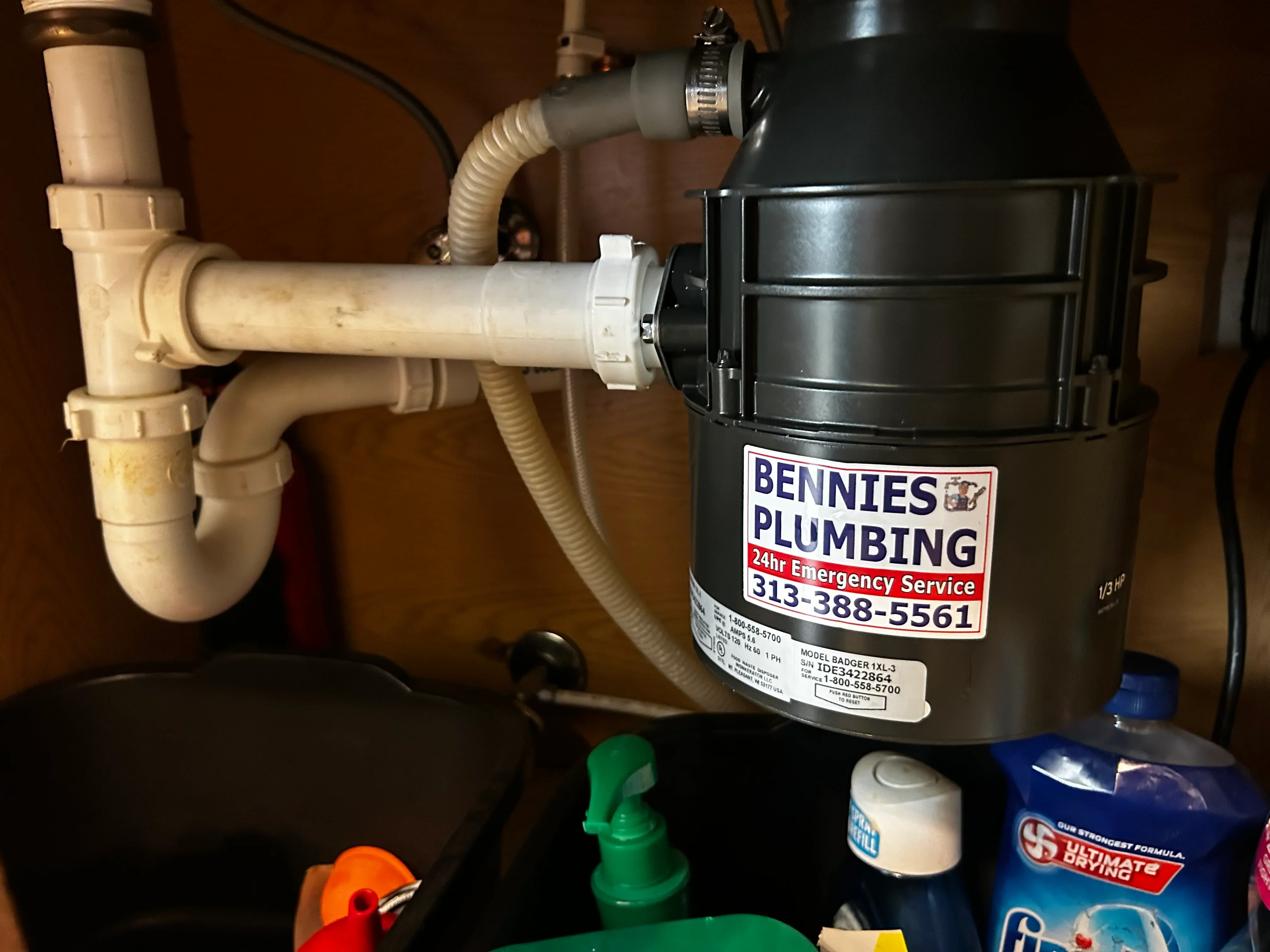 Installed sump pump with PVC piping, discharge hose, and check valve assembly in basement
