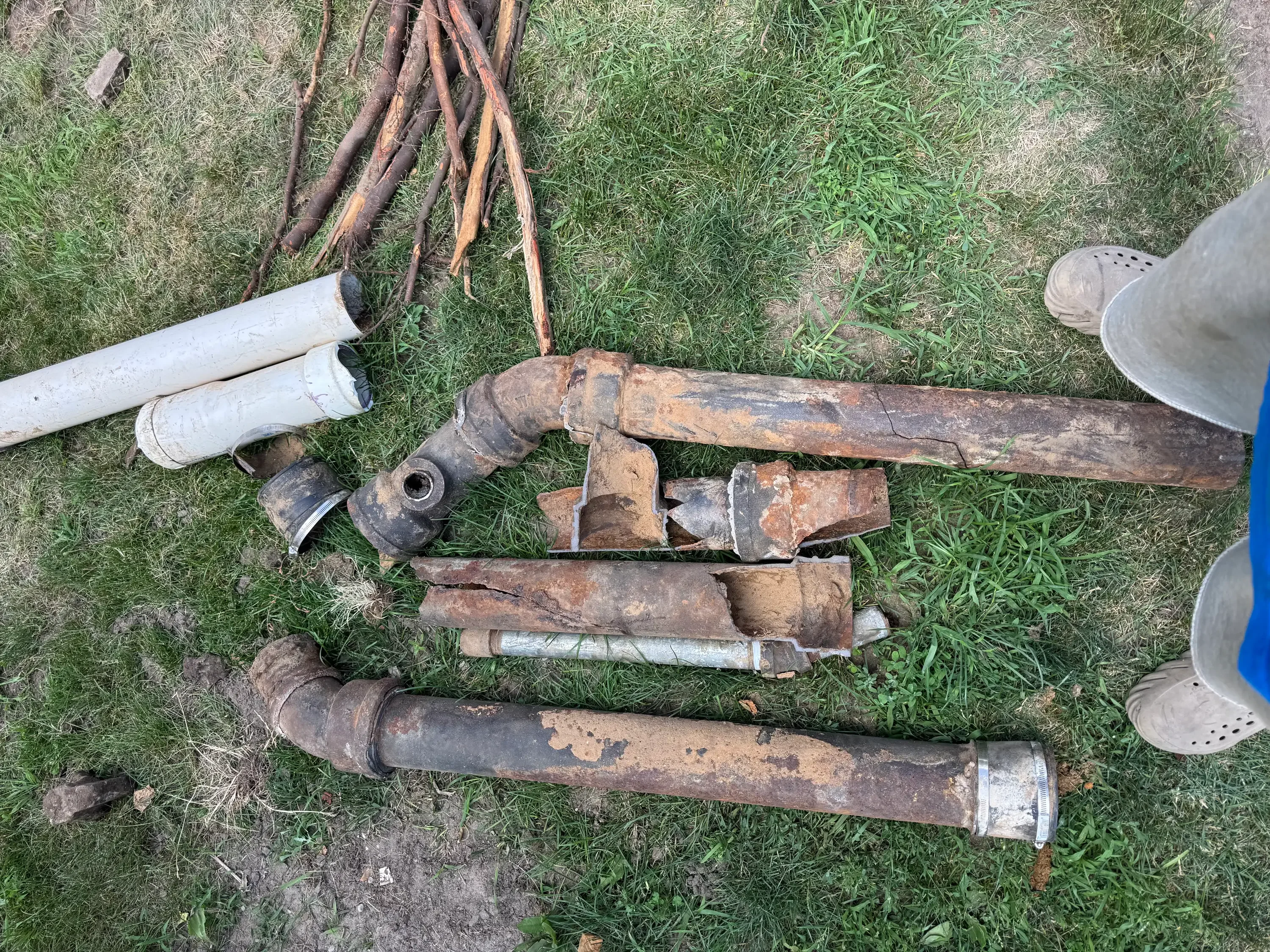 Removed corroded cast iron and galvanized steel pipes with fittings and modern PVC replacement sections